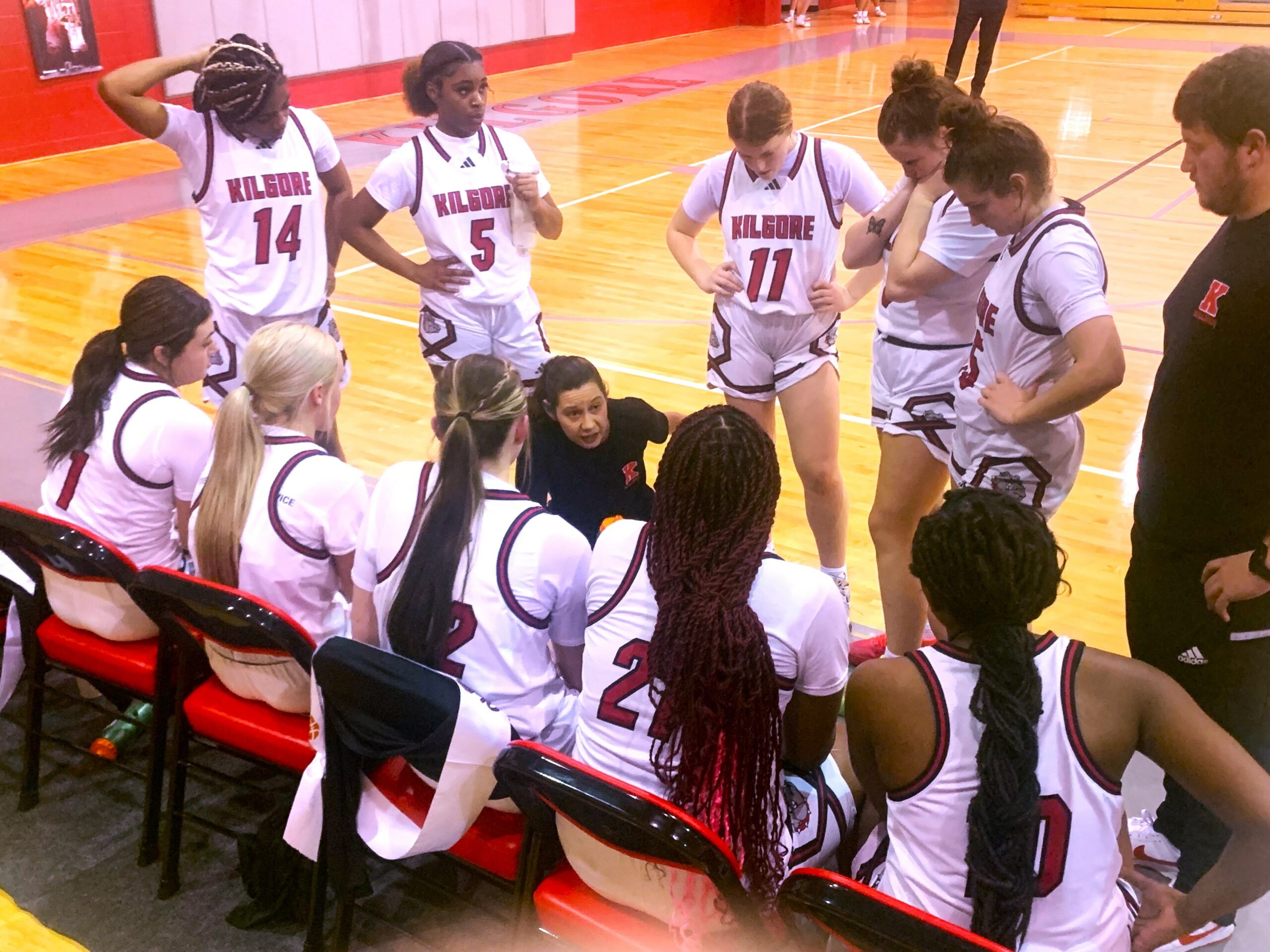 Kilgore girls basketball coach Marissa Coop (center, kneeling) talks to her team during a time-out against Carthage. The girls dropped the contest to Carthage, 42-17, but Kilgore's boys defeated Carthage, 60-40, in the nightcap. The Hi-Steppers got a great ovation after a performance during the boys' halftime. (Photo by MITCH LUCAS - ETBLITZ.COM)
