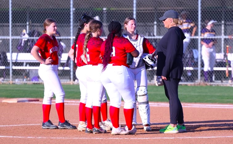 Kilgore first-year softball head coach Lacey Middlebrooks (right) talks to her infield during a break in the action on Thursday night at Stream-Flo Field in Kilgore. Kilgore dropped the home game to Center, 9-6. (Photo by DENNIS JACOBS)
