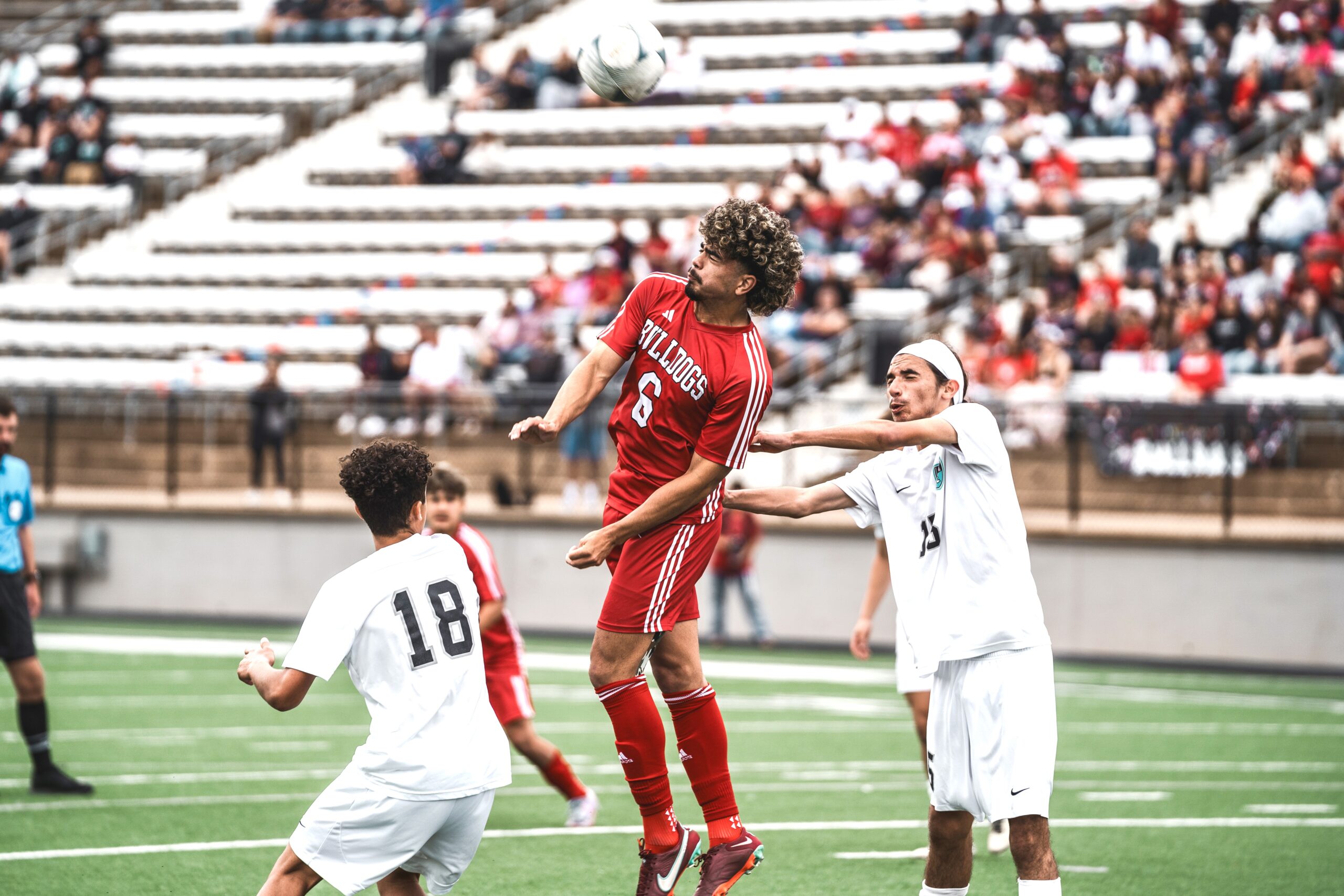 Kilgore's Leo Yzaguirre (center) executes a header in a recent playoff game. Yzaguirre and teammates Chris Martinez, Adan Reyes, Diego Rojas, coach Hector Peralez, and three players from Sabine -- Jesus Duran, Luke Kirkindoll, and Francisco Perez -- have all been honored with the release of this year's Texas Association of Soccer Coaches' Class 4A All-State and All-Region teams. (Photo by ALEX NABOR - ETBLITZ.COM)