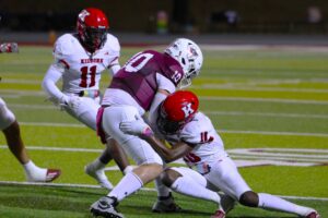 Kilgore's Jamarian Duncan (10) and La'Perrion Graves (11) wrap up Palestine quarterback Rohyn Price. Kilgore was all over Palestine Friday night, to the tune of a 52-7 final. Below: members of the KHS Hi-Steppers in action at Wildcat Stadium at halftime Friday night.