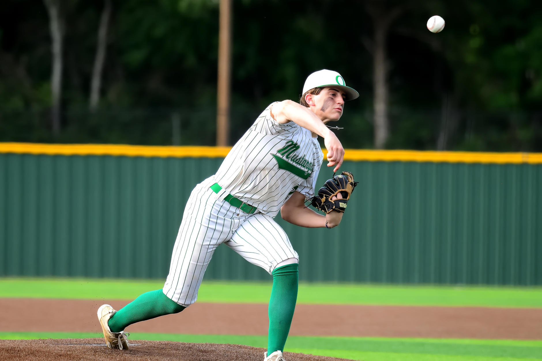 Rylan Holleman on the mound for the Overton Mustangs. Overton led Frankston by four runs (5-1) on Thursday night, but let the lead slip away in the UIL Class 2A bi-district round playoff. But it's a best-of-three series and it resumes tonight in Winnsboro at 7:30 p.m., with game two. Below: Mason Rowe attempts a pick-off, but the runner was ruled safe. (Photo by RONNIE SARTORS -SPORT SHOT PHOTOGRAPHY)