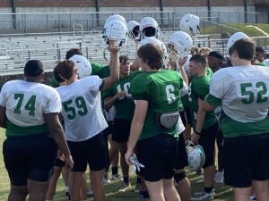 Members of the Overton High School Mustangs football team are led by coach Scotty Laymance (out of view) right before dismissing from a recent practice. Overton, which went 10-2 last season and into the second round of the UIL Class 2A playoffs, is looking to take another step farther, or more, in 2024. Also below: the Kilgore High School helmet: Respect the K. (Photos by MITCH LUCAS - ETBLITZ.COM)