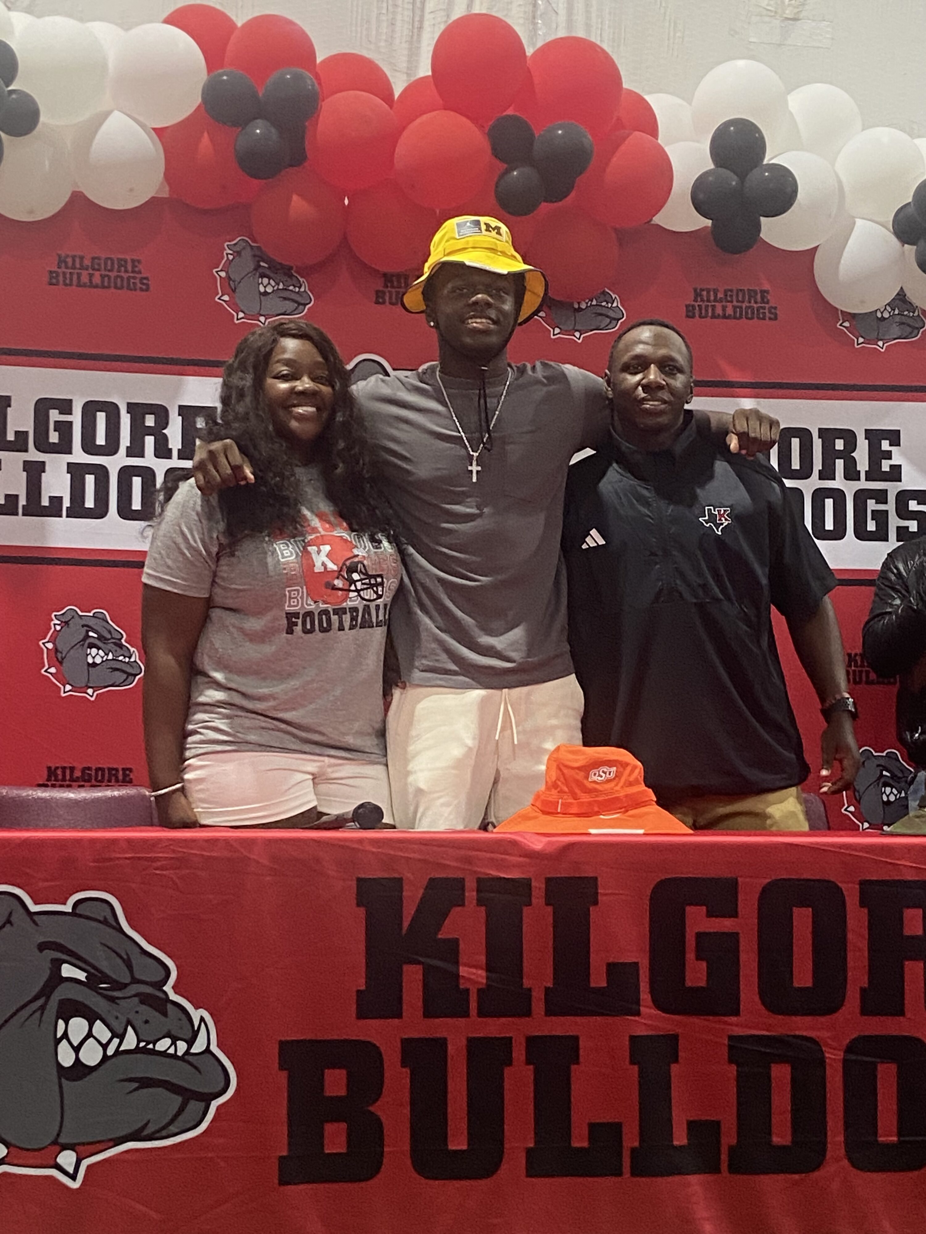 Kilgore High School defensive back / wide receiver Jayden Sanders committed to the University of Michigan on Saturday morning; he's joined here by his mom, Whitney Clark, and dad, Nick Sanders, and then below, the Kilgore High School coaching staff. (Photos courtesy of WHITNEY CLARK)