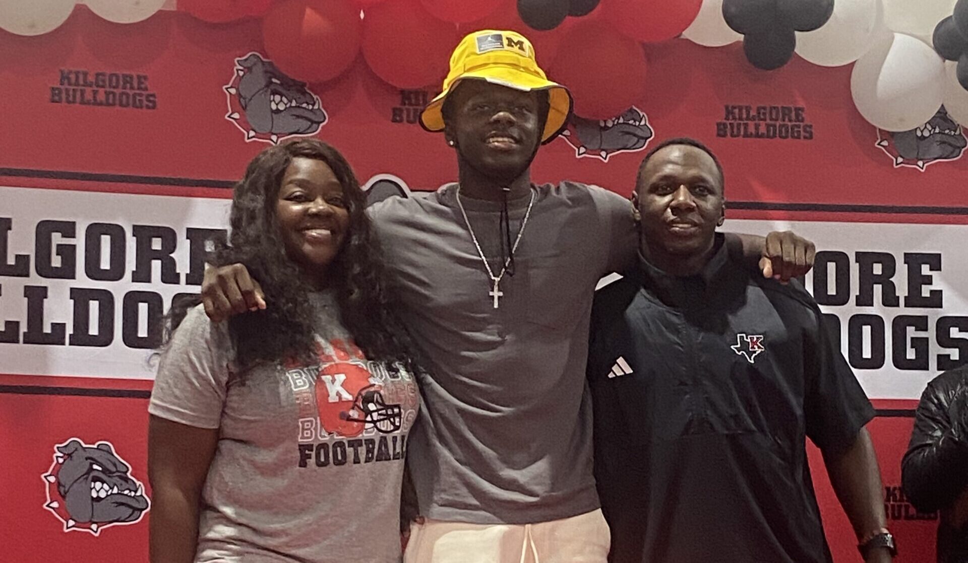 Kilgore High School defensive back / wide receiver Jayden Sanders committed to the University of Michigan on Saturday morning; he's joined here by his mom, Whitney Clark, and dad, Nick Sanders, and then below, the Kilgore High School coaching staff. (Photos courtesy of WHITNEY CLARK)