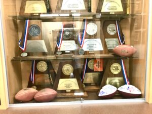 The trophy case at Gilmer High School's football field house is an impressive one. But there's always room for one more. And the Buckeyes, led by coach Alan Metzel (below), hope to do just that in the 2024 season, which would make them back-to-back UIL Class 4A Division II state champions, if they can pull off the feat. (Photos by JOE HALE - ETBLITZ.COM)